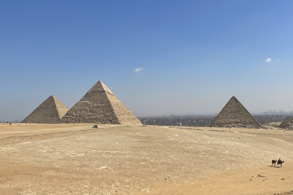 Die drei Pyramiden von Gizeh mit der Skyline von Kairo im Hintergrund