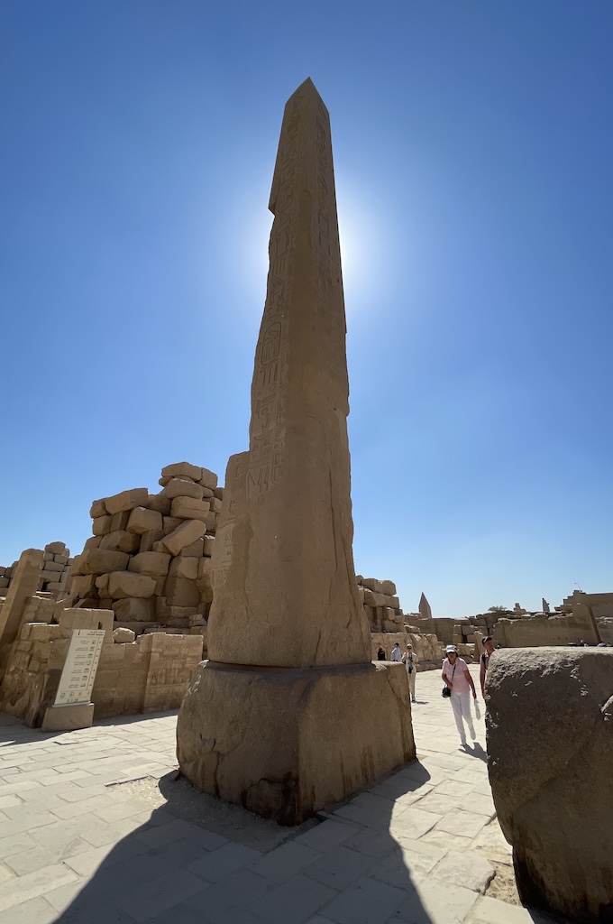 Sonnenbeschienener Obelisk im Karnak-Tempel von Luxor gegen blauen Himmel