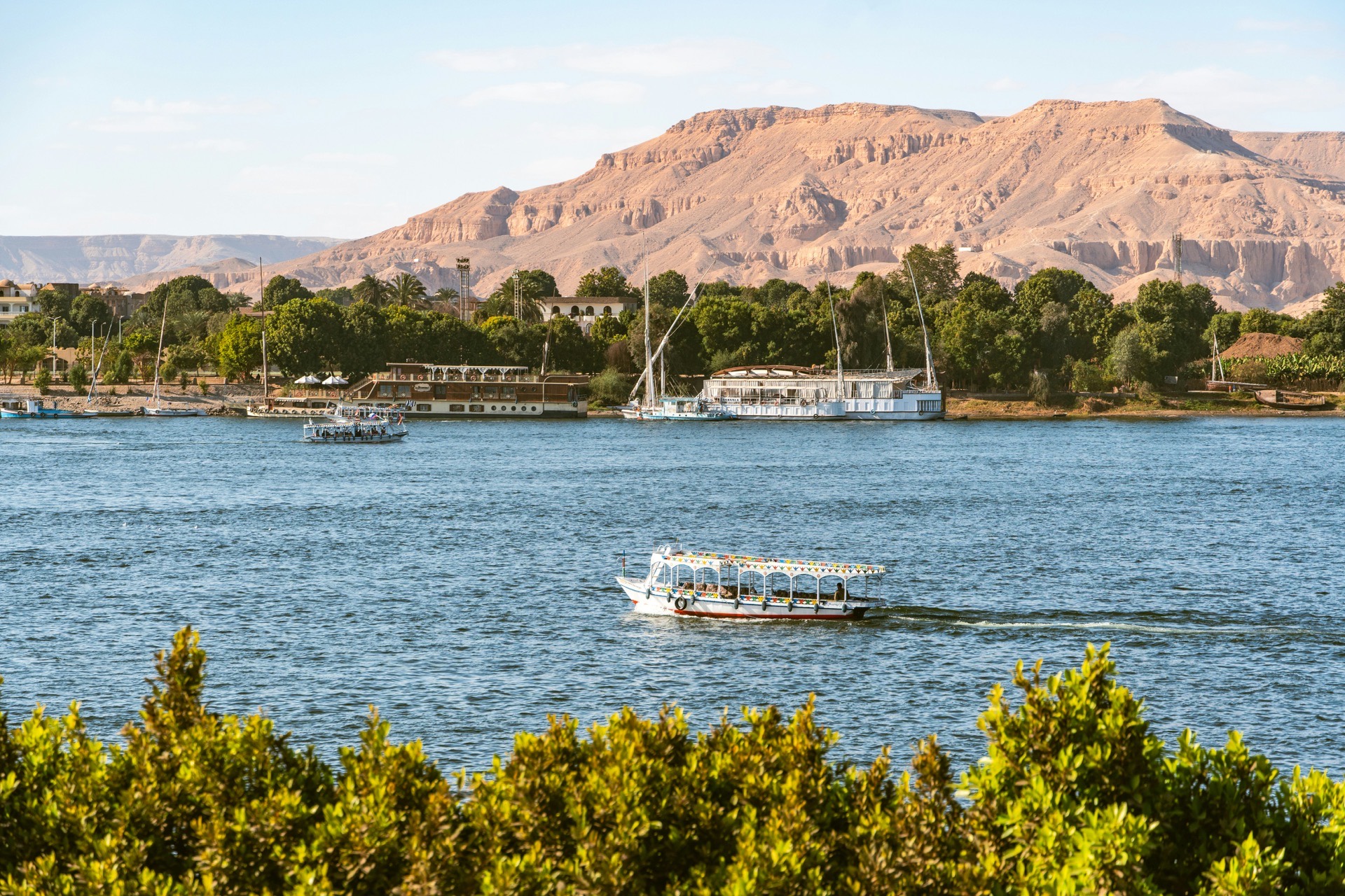 Ausflugsboote auf dem Nil bei Luxor vor den thebanischen Bergen
